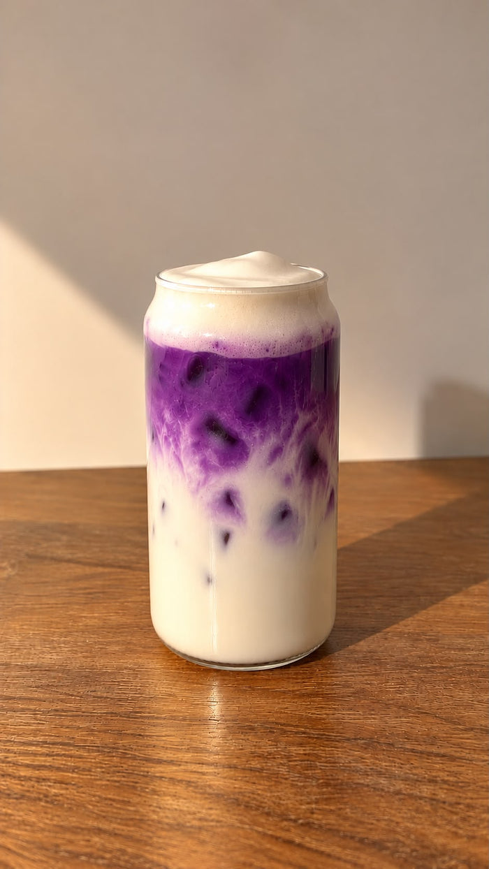 Iced Ube Latte Laya glacé, dégradé violet et lait de coco avec mousse sur le dessus