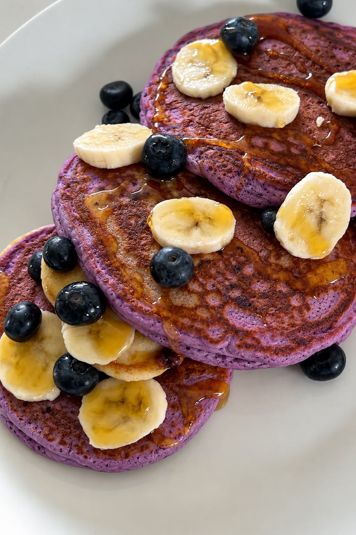 Pancakes violets à l’ube avec banane, myrtilles et sirop