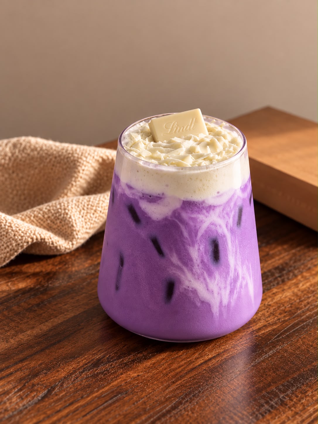 White Chocolate Ube Latte glacé avec mousse et copeaux de chocolat blanc