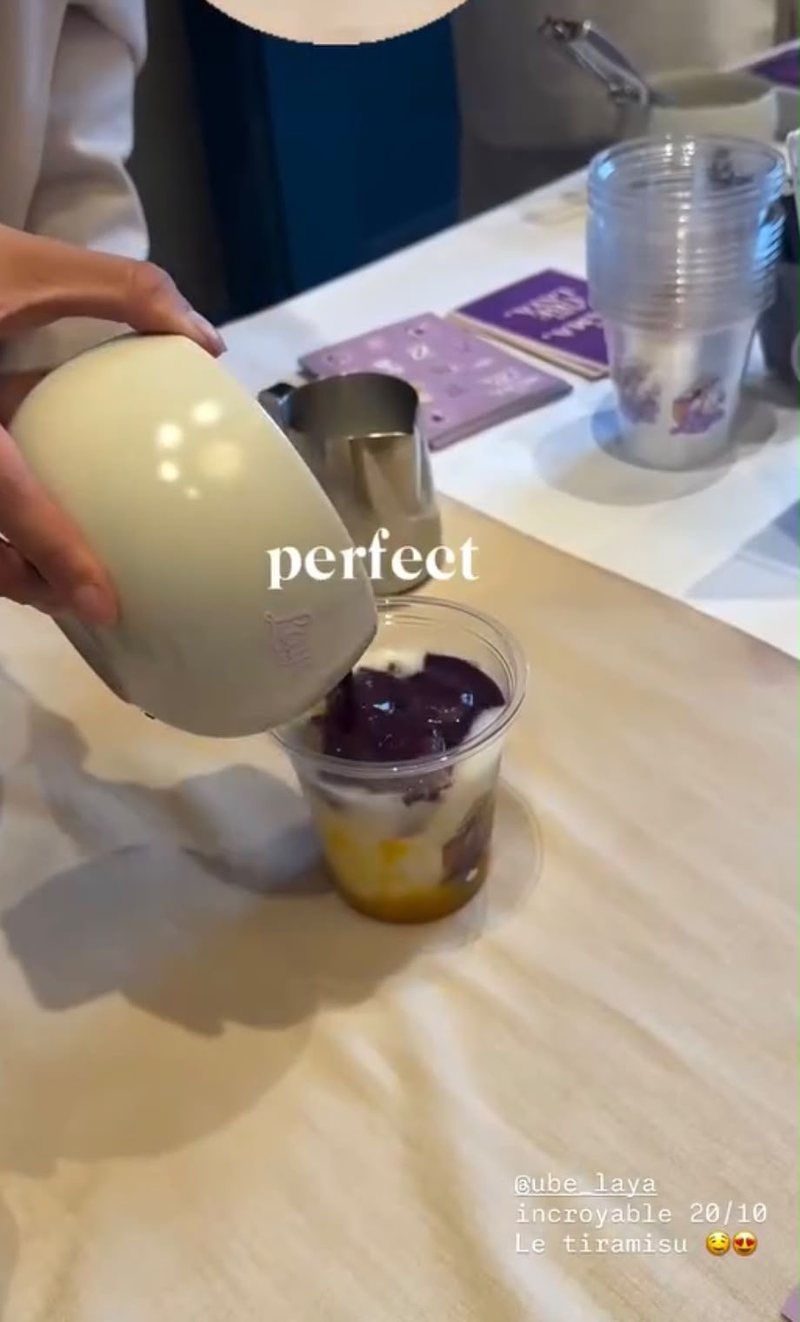 Ube latte poured over a mango base in a Laya cup